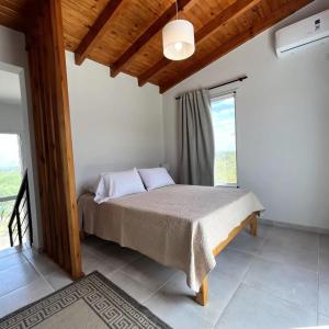 1 dormitorio con cama y ventana grande en Arcobaleno Casas Serranas en San Javier