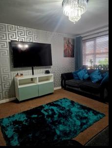 sala de estar con TV de pantalla plana y sofá en Well Furnished 3 Bedroom House in a cosy estate in Bolton, en Bolton