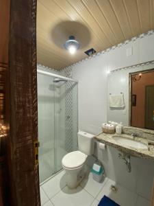 a bathroom with a toilet and a shower and a sink at Apartamento Charme Guará in Guaramiranga