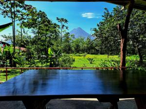a wooden bench with a view of a mountain at Casas de Campo Las Pavitas Cottages "Red Frog" in Palma +10 photos