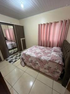 um quarto com uma cama com um cobertor rosa em RESIDÊNCIA COMPLETA 