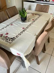 uma mesa com uma toalha de mesa branca e uma planta sobre ela em RESIDÊNCIA COMPLETA 