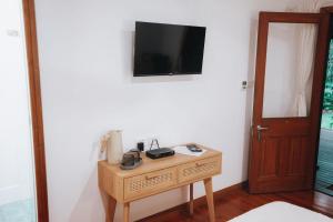 a room with a table with a television on a wall at Paperbark Retreat in Cooktown