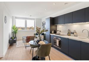 a kitchen and dining room with a table and a kitchen with a counter at Sophisticated Living: 1-BR Flat in Beckenham in Beckenham