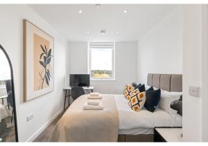 a white bedroom with a bed and a couch at Sophisticated Living: 1-BR Flat in Beckenham in Beckenham