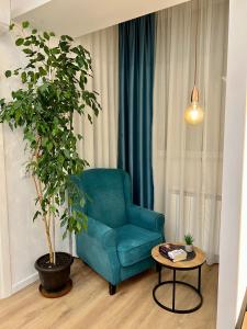 salon z niebieskim krzesłem i stołem w obiekcie The Great Square Luxury Apartments w mieście Skopje