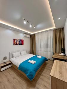 a bedroom with a large bed with two towels on it at The Great Square Luxury Apartments in Skopje