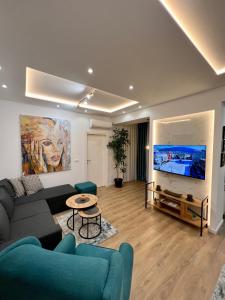 salon z kanapą i telewizorem z płaskim ekranem w obiekcie The Great Square Luxury Apartments w mieście Skopje
