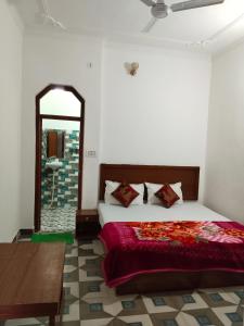 a bedroom with a bed and a mirror at Rani Palace in Khajurāho