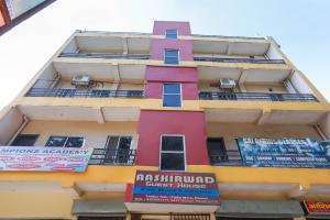 un edificio alto con letreros a un lado. en Flagship Aashirwad Guest House en Ranchi