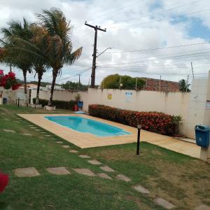 a swimming pool in a yard next to a fence at Recanto Casa SOL in Barra de Jacuípe