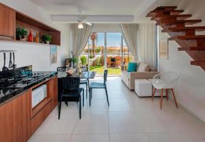 una cucina e un soggiorno con tavolo e sedie di The Coral Resort - Loft na Praia de Flecheiras a Trairi