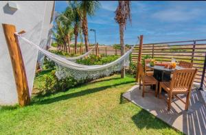 un'amaca in un cortile con tavolo e sedie di The Coral Resort - Loft na Praia de Flecheiras a Trairi