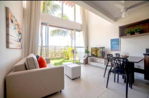 un soggiorno con un divano e un tavolo di The Coral Resort - Loft na Praia de Flecheiras a Trairi