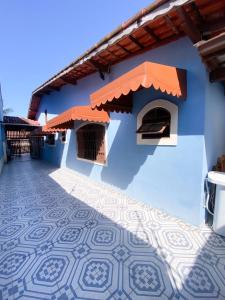 a blue building with a tile floor in front of it at Casa em Mongaguá Plataforma in Mongaguá