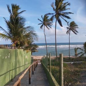 un sentiero che conduce alla spiaggia con palme di Recanto Casa SOL a Barra de Jacuípe