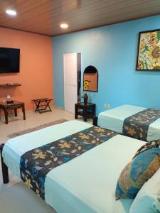 Habitación con 2 camas y TV. en Casa las Flores en Puerto Vallarta