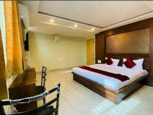 um quarto com uma cama grande e almofadas vermelhas em Yashaswiny recidency em Mysore