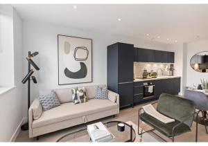 ein Wohnzimmer mit einem Sofa und einer Küche in der Unterkunft Cosmopolitan Living: Upscale 1BR Gem in Beckenham in Beckenham