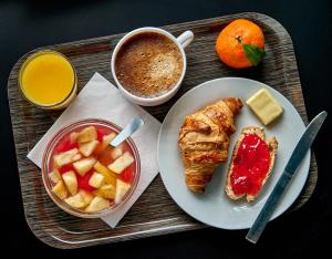 a tray of food with a plate of fruit and a cup of coffee at Kyriad Direct Nevers Nord - Varennes Vauzelles in Varennes Vauzelles