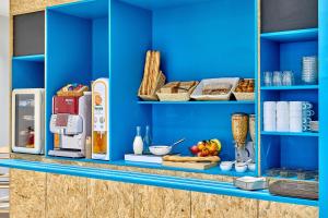 una estantería azul con comida y otros artículos. en Kyriad Direct Nevers Nord - Varennes Vauzelles, en Varennes Vauzelles