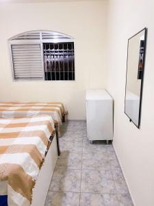 a row of beds in a room with a window at Casa em Mongaguá Plataforma in Mongaguá