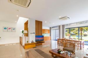 a living room with a dining table and a television at Champa Island Nha Trang - Resort Hotel & Spa in Nha Trang