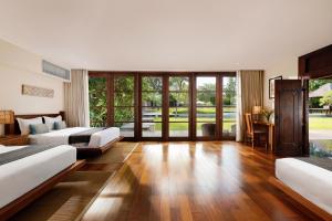Una habitación de hotel con dos camas y un escritorio. en Villa Amita by Nakula, en Kerobokan