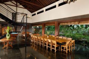 une salle à manger avec une grande table et des chaises en bois dans l'établissement Villa Amita by Nakula, à Kerobokan