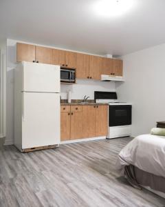 a kitchen with a white refrigerator and wooden cabinets at Studio apartment with 1 bed - 242 in Montréal