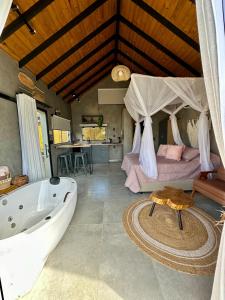a bathroom with a bath tub and a bedroom at Cabanas Sonho Rosa - com banheira hidro e cesta de café cortesia na primeira manhã in Imbituba