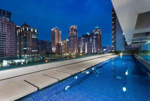 a swimming pool on the roof of a building with a city skyline at Millennium Hotel Taichung in Taichung