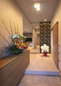 un pasillo con dos jarrones de flores en un mostrador en 湯音の森, en Kusatsu