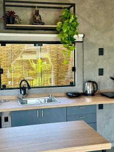 a kitchen counter with a sink and a window at Cabanas Sonho Rosa - com banheira hidro e cesta de café cortesia na primeira manhã in Imbituba +66 photos