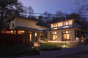 a house with its lights on in the night at 湯音の森 in Kusatsu