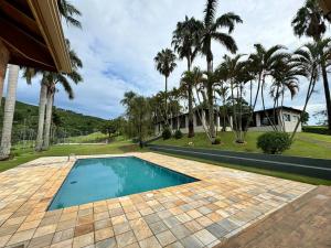 una piscina en un patio con palmeras en Casa de Campo Monte Sião, en Monte Sião