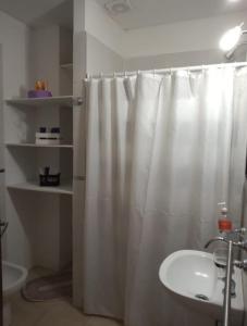y baño con cortina de ducha y lavamanos. en Dúplex Miramar en Miramar
