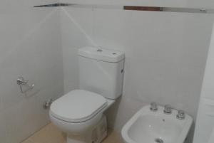 Baño blanco con aseo y lavamanos en Dúplex Miramar en Miramar