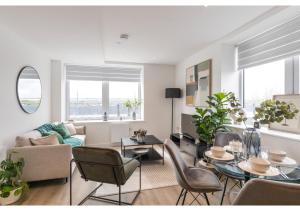 uma sala de estar com um sofá, uma mesa e cadeiras em Designer Flat in Prime Location em Beckenham