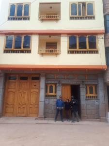 drie mannen die voor een gebouw staan bij casa marfil tourist house in Cuzco