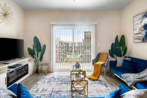 uma sala de estar com um sofá azul e uma televisão em BRAND NEW Luxurious, Spacious, Gated 2bd Apt em Houston