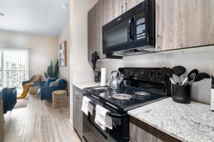 a kitchen with a stove and a microwave at BRAND NEW Luxurious, Spacious, Gated 2bd Apt in Houston