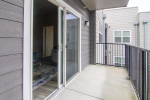 un porche cerrado con puertas correderas de cristal en una casa en BRAND NEW Luxurious, Spacious, Gated 2bd Apt, en Houston