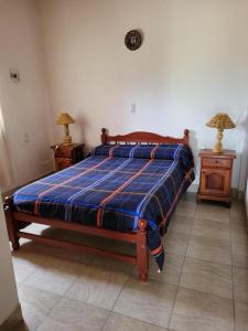 1 cama en un dormitorio con 2 mesitas de noche y 2 lámparas en Cabañas Kurmi en Humahuaca