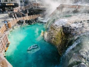 una vista aerea di una sorgente termale con cascata di 草津温泉、スキー場、湯畑、熱帯圏車で5分以内！最大27人宿泊可能 a Kusatsu