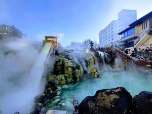 una vista su una cascata con persone che lo circondano di 草津温泉、スキー場、湯畑、熱帯圏車で5分以内！最大27人宿泊可能 a Kusatsu