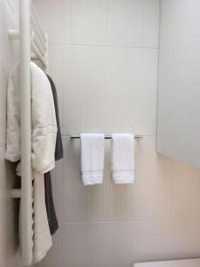 La salle de bains est pourvue de serviettes blanches suspendues à un portant. dans l'établissement Lovely studio withn view in Saint Germain, à Paris