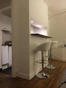 une cuisine avec deux tabourets de bar et un comptoir dans l'établissement Lovely studio withn view in Saint Germain, à Paris