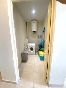 a hallway leading to a laundry room with a washing machine at Appartement spacieux Les Anses-d'Arlet 100 m² vue mer et montagne in Les Anses-dʼArlets
