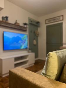 sala de estar con sofá y TV de pantalla plana en Arce 23 en Buenos Aires